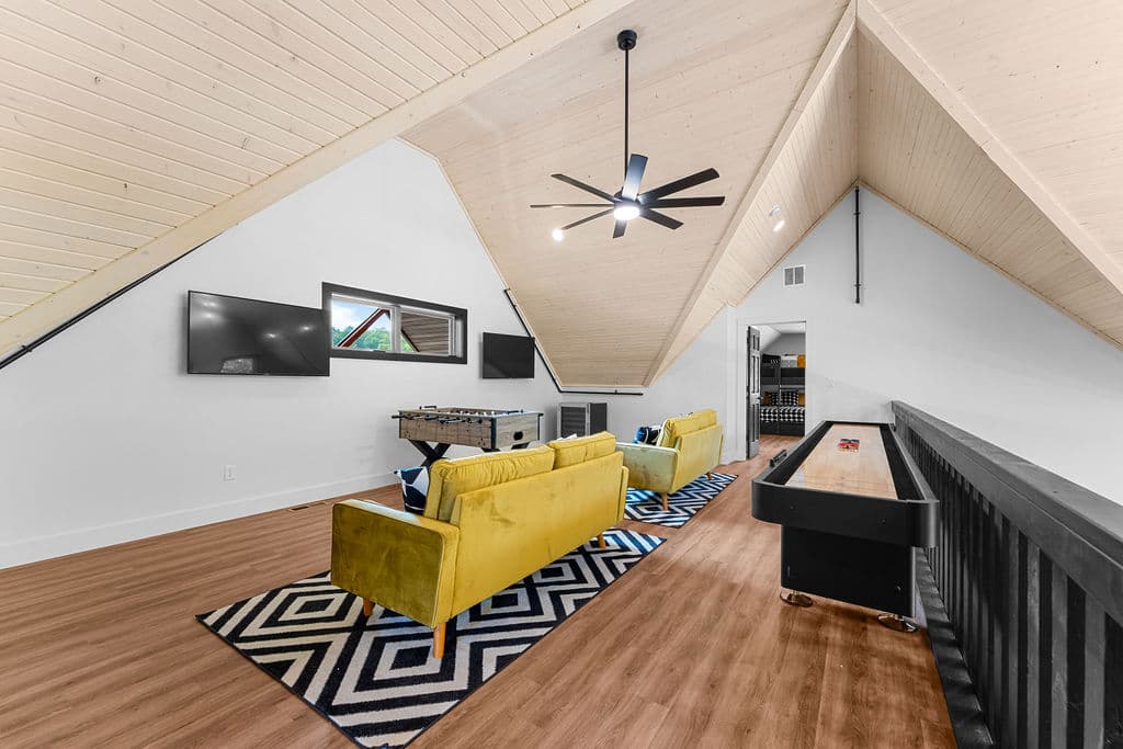 Upstairs game room with 2 TVs, foosball table and shuffleboard table