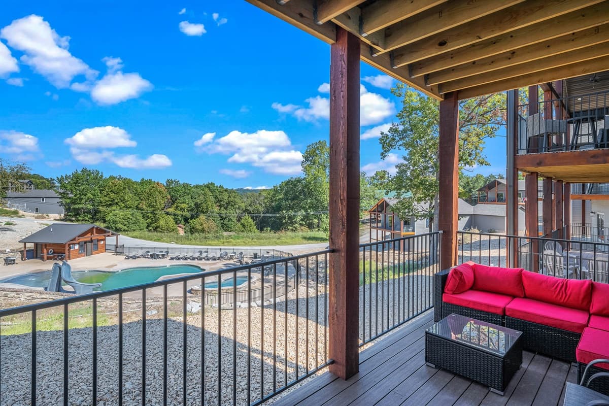 Upper deck with dining seating and outdoor couches provides a perfect vantage point for observing the community pool and hot tub