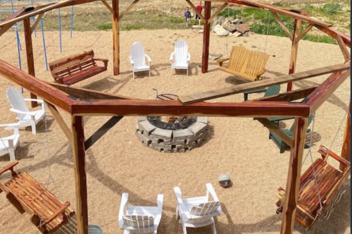 Octagonal swing structure surrounding the wood firepit is a unique space we know your group will love!