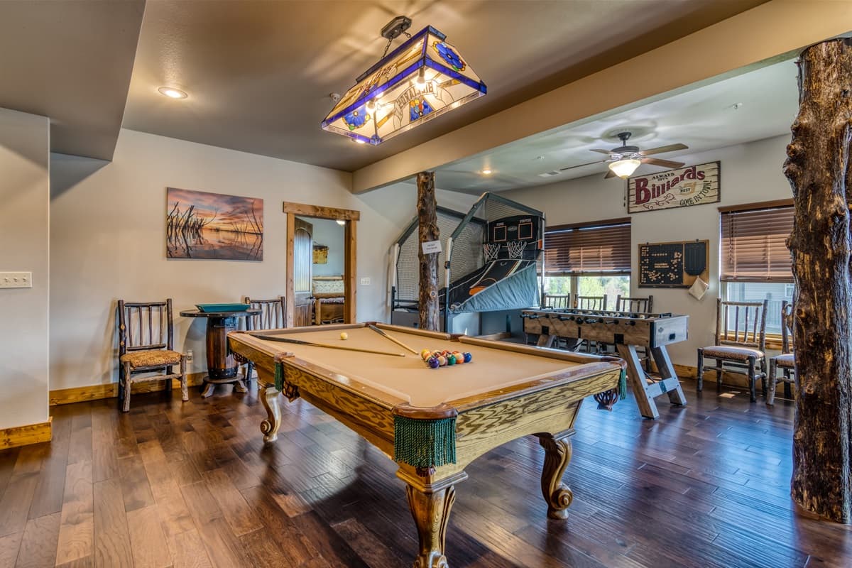 Lower level game space with pool table, basketball game, and foosball